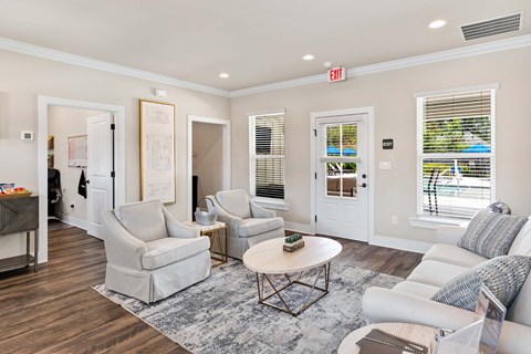 A living room with white furniture and a grey rug.