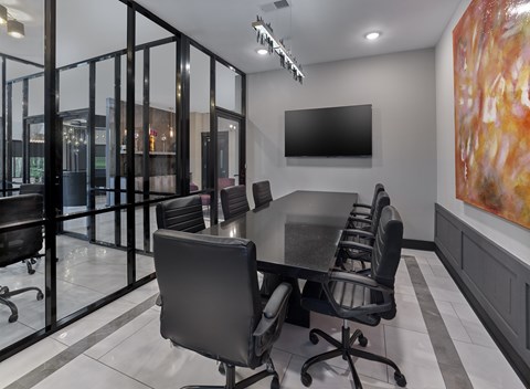 A conference room with a long table and chairs.