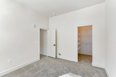A room with a carpeted floor and a white door.