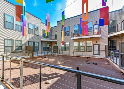 A playground area with a fence and colorful flags.