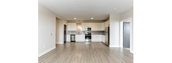 A modern kitchen with white cabinets and stainless steel appliances.
