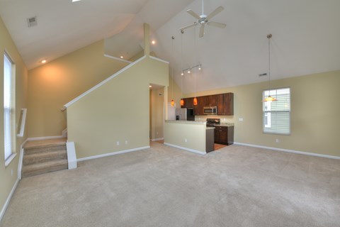 A spacious room with a staircase leading to the upper level.