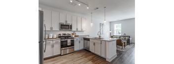 A modern kitchen with white cabinets and stainless steel appliances.