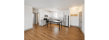 A kitchen with a table and chairs in the middle of the room.