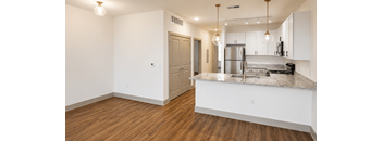 A kitchen with a refrigerator, microwave, and oven.