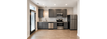 A modern kitchen with dark wood cabinets and stainless steel appliances.