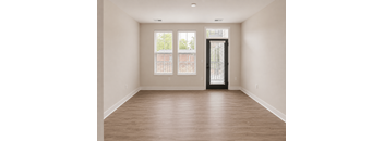 A room with a wooden floor and a door with a window on the side.