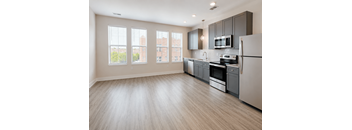 A kitchen with a refrigerator, oven, and microwave.