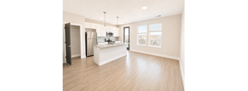A spacious kitchen with a refrigerator, microwave, and oven.