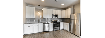 A kitchen with white cabinets and stainless steel appliances.