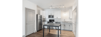 A kitchen with a table and chairs in the middle of the room.