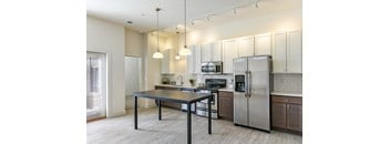 A modern kitchen with a table and stainless steel appliances.