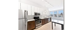A modern kitchen with a stainless steel refrigerator and wooden cabinets.