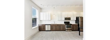 A kitchen with white cabinets and a black stove top oven.