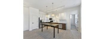 A kitchen with a table and chairs in the middle of the room.