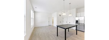 A spacious kitchen with a table and a refrigerator.
