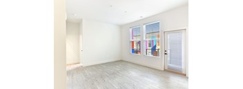 A room with a large window and a painting on the wall.