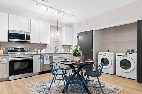 A modern kitchen with a dining table set for two.