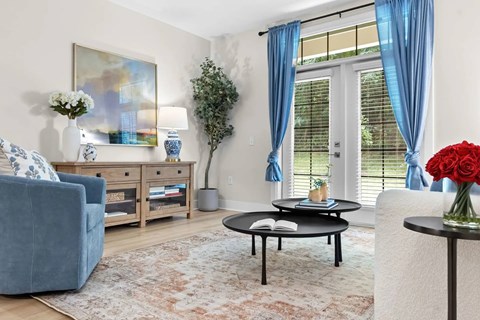 A living room with a blue couch, a coffee table, and a painting on the wall.