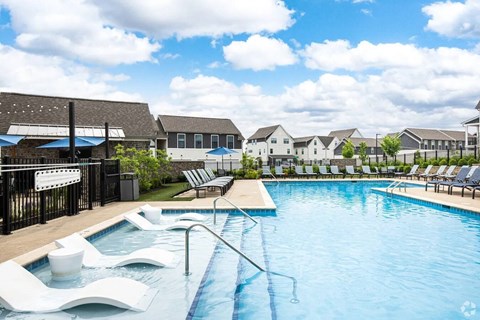 A pool with a slide and sun loungers.