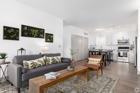 A living room with a grey couch and a coffee table in front of it.