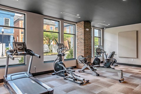 A gym with treadmills, exercise bikes, and a weight machine.