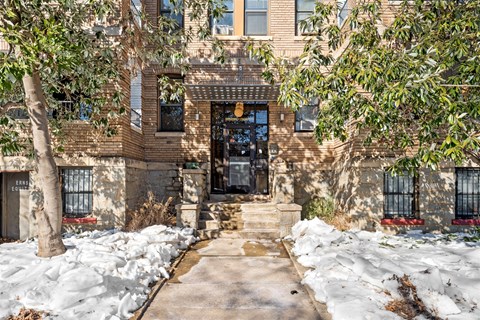 A snow-covered pathway leads to a building entrance.