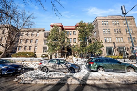 Cars are parked on a street with snow on the ground.