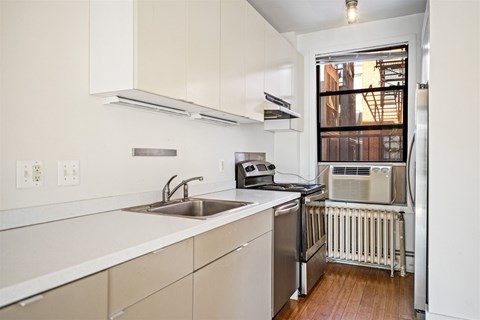 A kitchen with white cabinets and a stainless steel dishwasher.