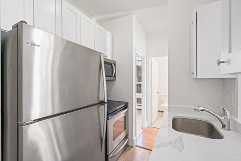 A kitchen with a stainless steel refrigerator and a sink.