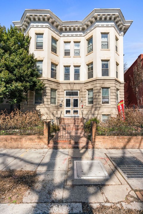A large, two-story building with a red flag on the right side.