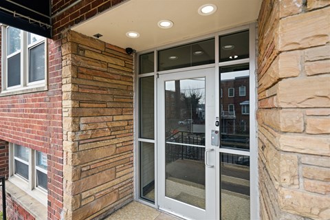 A glass door with a handle is on a stone wall.
