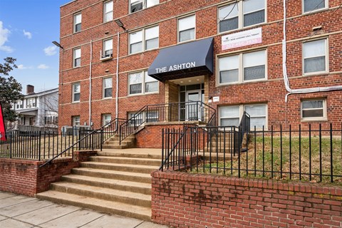 The Ashton is a red brick building with a black awning.