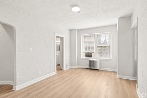 A room with a window and a radiator on the floor.