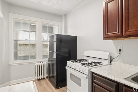 A black refrigerator sits next to a white stove in a kitchen.