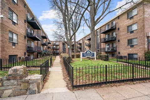 A row of apartment buildings with a sign that says Alexander.