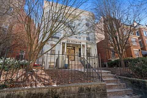 A building with a sign that says "The Hermon" is in front of some trees.