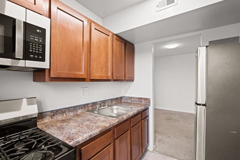 A kitchen with brown cabinets and a stove top oven.