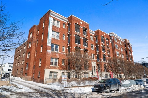 A large red brick building with a car parked in front.