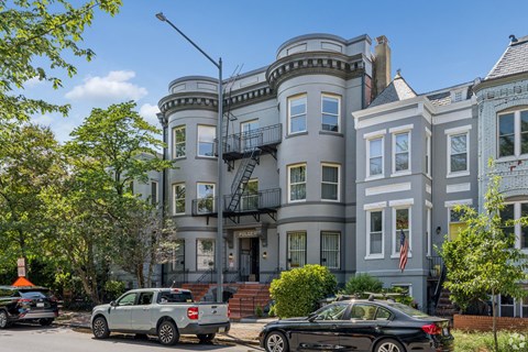 A large, multi-story building with a grey exterior and a balcony on the second floor.