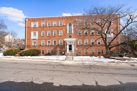 A red brick building with a white door and windows.