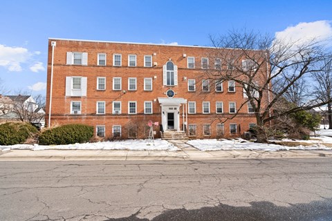 A red brick building with a white door and windows.