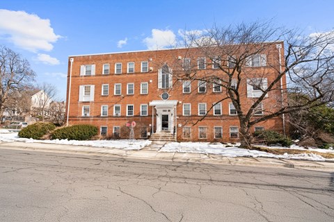 A large red brick building with a white door and windows.