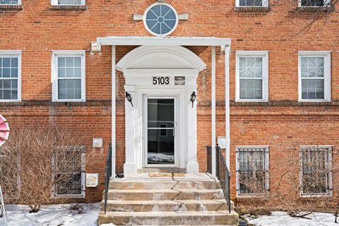A red brick building with a white door and windows.