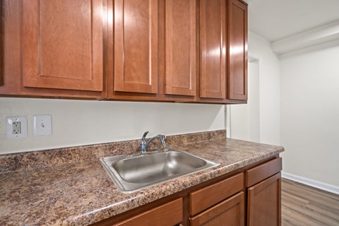 A kitchen with brown cabinets and a granite countertop.