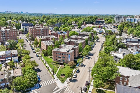 A city street with a crosswalk and a large building in the background.