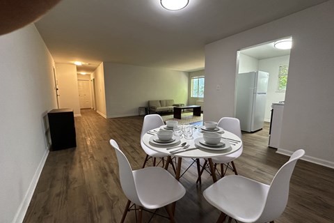 A dining room with a white table and chairs.