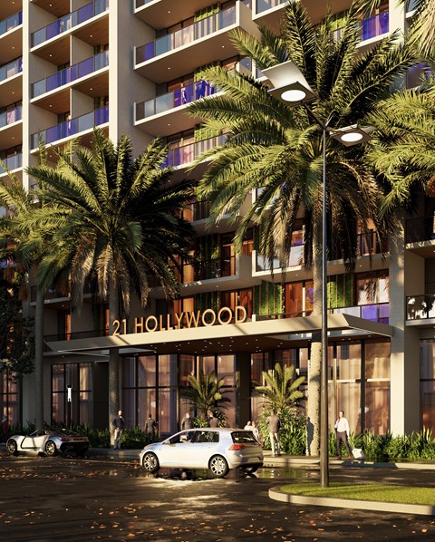A white car is parked in front of a building with the sign "21 Hollywood".