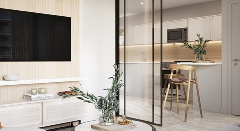 A modern kitchen with a glass partition and a dining table with chairs.
