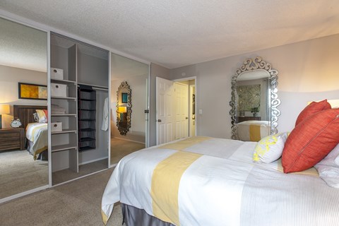 A bedroom with a large bed and a mirror on the wall.